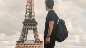 Young man in Paris looking at the Eiffel Tower