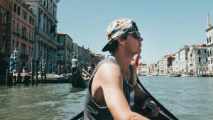 Young man sitting on a boat in a canal in Venice