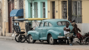 Several men sitting on a vintage car in La Habana, Cuba