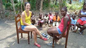 Faculty interviewing a child outdoors with many onlookers in São Tomé and Príncipe