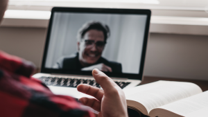 Two men talking virtually through a laptop video call