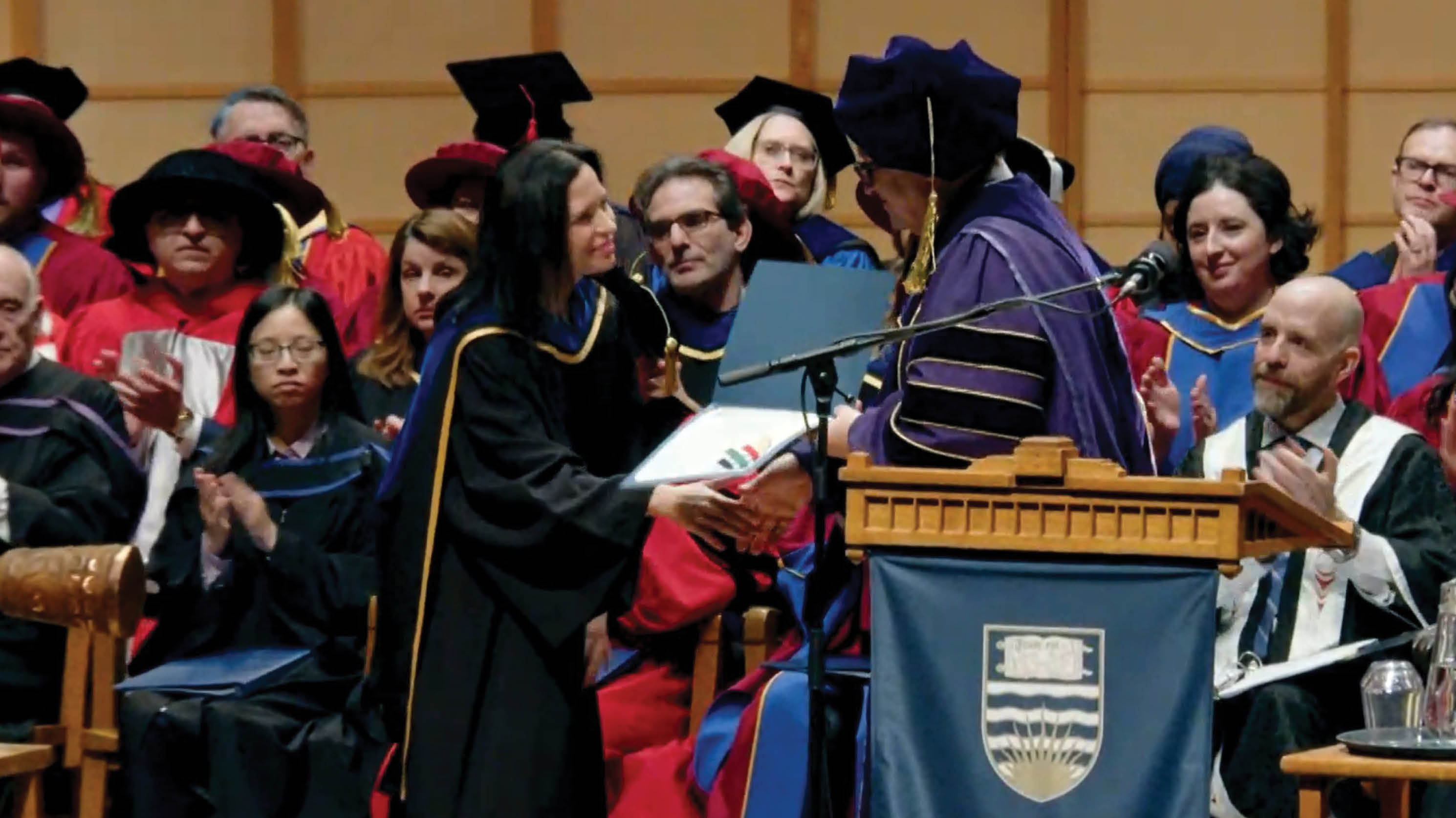 Kim Beauchesne shaking hands with Gage Averill and receiving the Killam Award for Excellence in Mentoring.